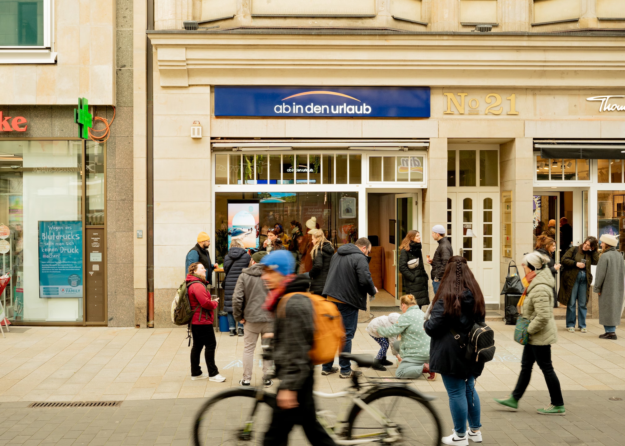 Menschen laufen am Reisebüro "ab in den urlaub" in der Leipziger Innenstadt vorbei