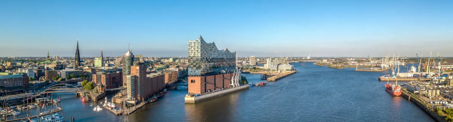 Blick auf die Elbphilharmonie und den Hamburger Hafen bei Sonnenschein – Startpunkt vieler Kreuzfahrten